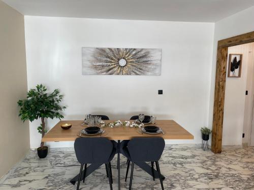 a dining room with a wooden table and two chairs at New apartment at 150m from the beaches Easy check in in Juan-les-Pins