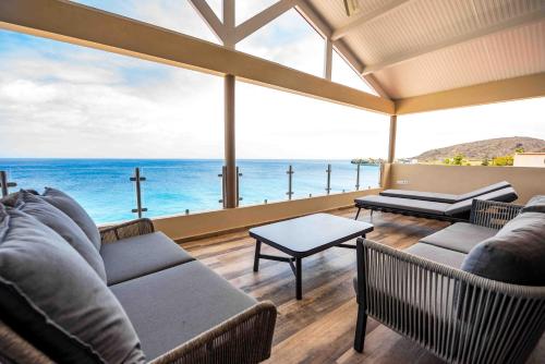 a living room with a view of the ocean at Lagun Sunset Resort All Natural Clothing Optional in Lagun