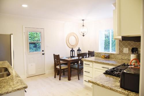 a kitchen with a table and a dining room at Mile to Beach! Fully Fenced Private SoCal Cottage in Oceanside