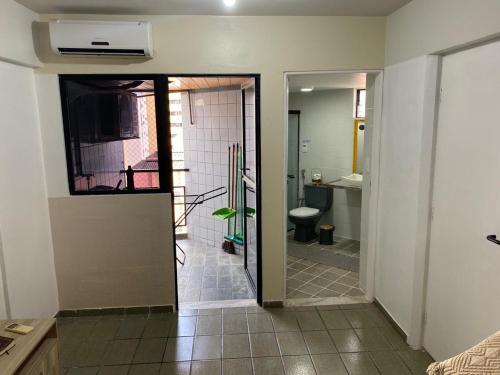 una puerta abierta a un baño con lavabo y aseo en Ponta Verde com Manobrista, lavadora de Roupas, Wi-fi - Apto 405, en Maceió