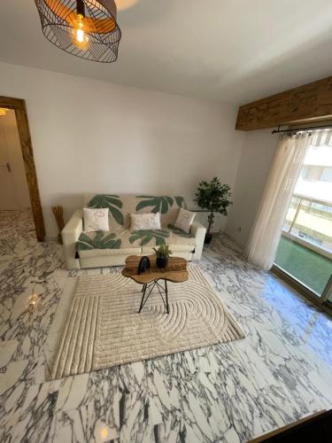 a living room with a couch and a table at New apartment at 150m from the beaches Easy check in in Juan-les-Pins