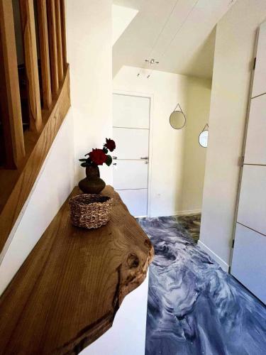 Cette chambre dispose d'une table avec un vase. dans l'établissement L'art du bonheur proche de la Baie de Somme, à Béhen