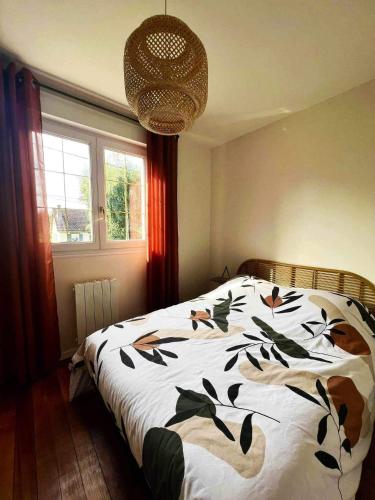 une chambre avec un lit avec une couette noire et blanche dans l'établissement L'art du bonheur proche de la Baie de Somme, à Béhen