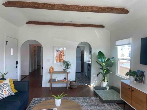 a living room with a blue couch and some plants at Huge Updated Spanish Apt - Steps to Beach & Bay! in Long Beach