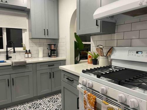 a kitchen with white cabinets and a stove top oven at Huge Updated Spanish Apt - Steps to Beach & Bay! in Long Beach