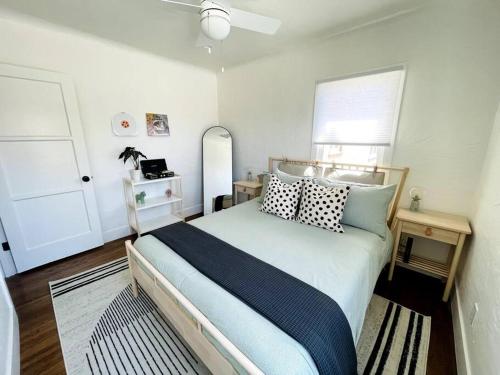 a bedroom with a bed with pillows and a window at Huge Updated Spanish Apt - Steps to Beach & Bay! in Long Beach