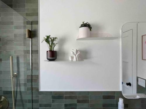 a bathroom with a shower with a plant on a shelf at Huge Updated Spanish Apt - Steps to Beach & Bay! in Long Beach