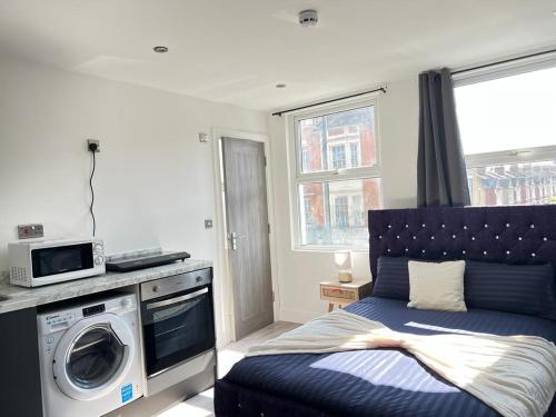 ein Schlafzimmer mit einem Bett und einer Waschmaschine in der Unterkunft Studio Apartments Central London in London
