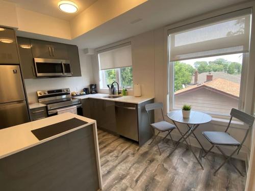 a kitchen with a sink and a table with chairs at Stylish Townhome Gem with Several Amenities Just Minutes To The Falls in Niagara Falls