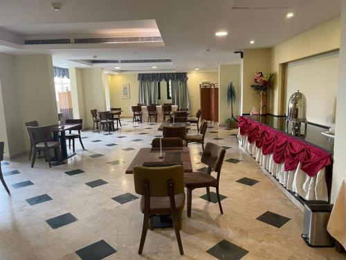 un restaurant avec des tables et des chaises ainsi qu'un bar dans l'établissement فندق حدائق فرسان الفندقية, à Ḩumr