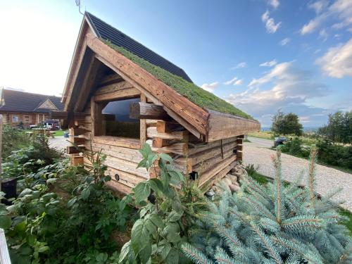 a small wooden building with a grass roof at SOPA Zakopane in Zakopane