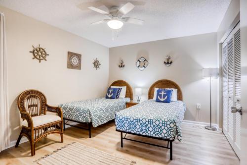 Cette chambre comprend deux lits, une chaise et un ventilateur. dans l'établissement Casa de Playa, à Saint Augustine