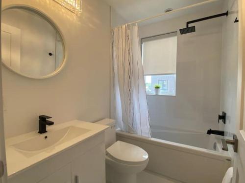 a bathroom with a sink and a toilet and a mirror at Stylish Townhome Gem with Several Amenities Just Minutes To The Falls in Niagara Falls