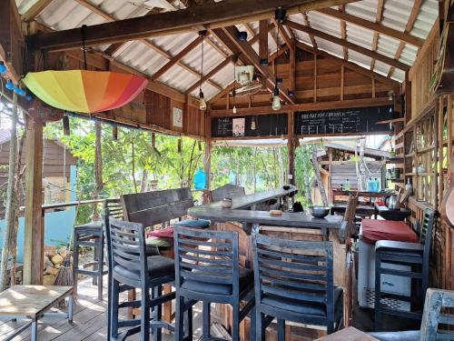 um restaurante com cadeiras, uma mesa e um bar em Dragonfly Guesthouse em Koh Rong Sanloem