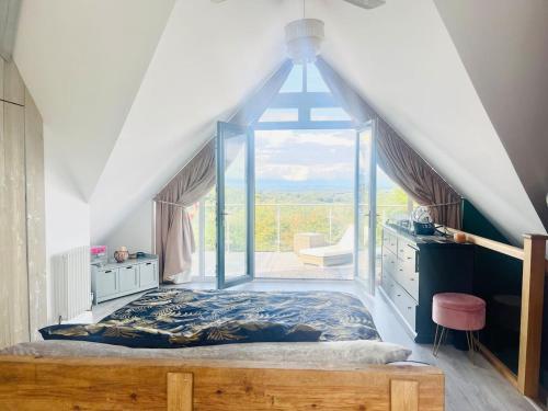 - une chambre avec un lit et une grande fenêtre dans l'établissement Modern Country Home with Cinema Room Overlooking Forestry, à West Hoathley