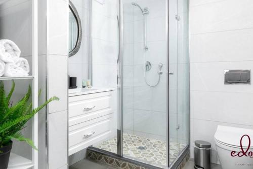 een badkamer met een douche en een glazen deur bij דירה מהפנטת במתחם סי סייד 100 מטר מהים - By Edom in Eilat