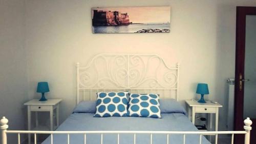una camera da letto con un letto bianco con due tavoli di Napulè a Napoli