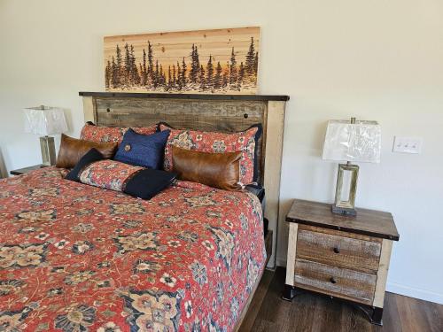 a bedroom with a bed and a table with lamps at Hidden Falls Retreat in Oakhurst