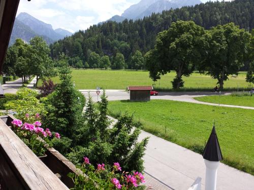 a view from the balcony of a yard with flowers at Hotel Kleiner König in Schwangau