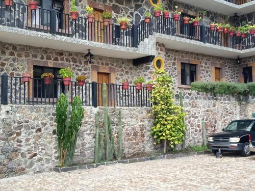 a car parked in front of a stone building with plants at Posada de las Monjas in San Miguel de Allende