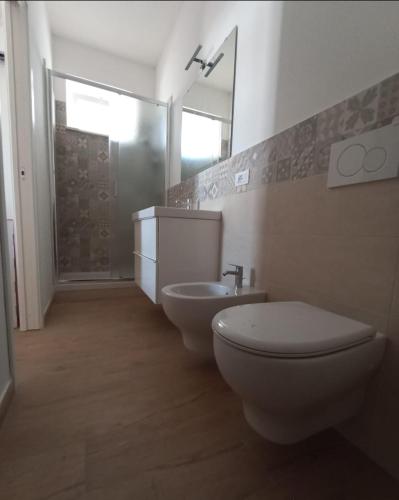 a bathroom with a toilet and a sink and a mirror at Holiday Home Ischia in Ischia