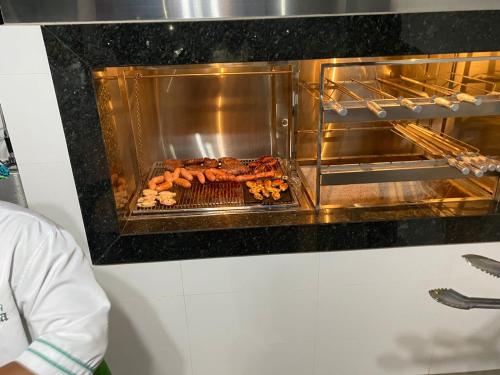 een grill met eten koken in een oven bij Pousada Chez bubônia in Novo Acordo