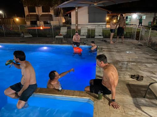 een groep mannen in een zwembad 's nachts bij Pousada Chez bubônia in Novo Acordo