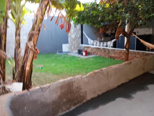 einen Hof mit zwei Bäumen und einem Haus in der Unterkunft Pousada do Julio in Barretos