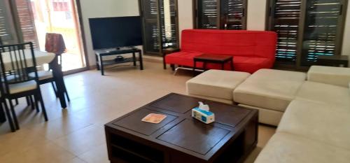 a living room with a couch and a red chair at Flat One Room Apartment Talabay Aqaba in Al Burj