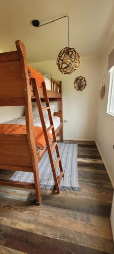 1 dormitorio con 2 literas y lámpara de araña en Karu-Terra cabin, en Huiscapi