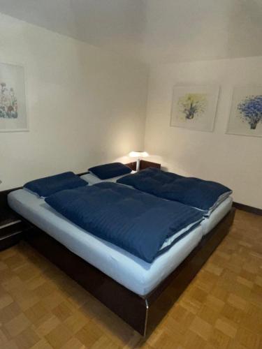 Ferienwohnung Urban - AHORN -- Meersburg في ميرسبرغ: سرير كبير وملاءات زرقاء في غرفة النوم