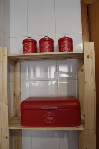 a red briefcase on a wooden shelf with red cups at Stylish 1br in Gaia near Porto, sleeps 4 in Vila Nova de Gaia