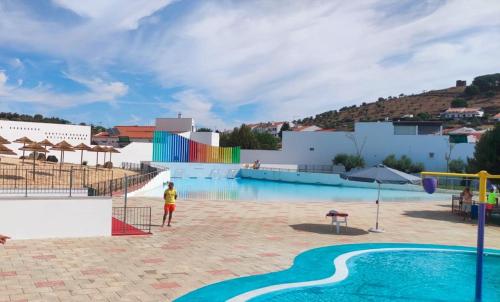 a person standing next to a large swimming pool at Cantinho da Bia - Alojamento Local in Portel