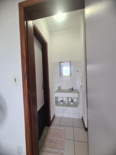 a bathroom with a sink and a mirror at Apartamento aconchegante in Jequié