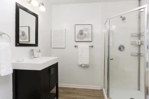 a white bathroom with a sink and a shower at 10 Min to Sea World & Lackland, Pets OK, Sleeps 12 in San Antonio