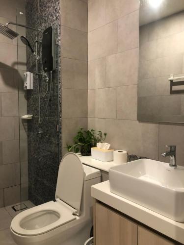 a bathroom with a toilet and a sink and a shower at Ems Executive Suites Home in Kota Kinabalu