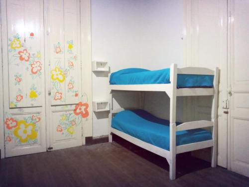 Zimmer mit Etagenbett, 2 Etagenbetten und einer Tür in der Unterkunft Casa Copada in Montevideo
