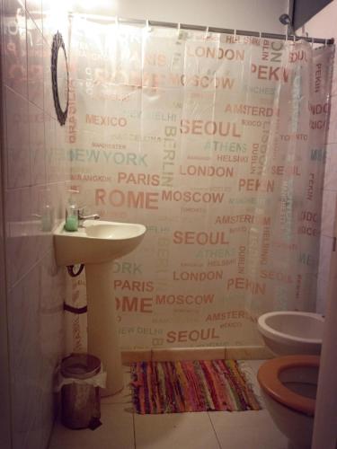 a bathroom with a shower curtain that has words on it at Casa Copada in Montevideo