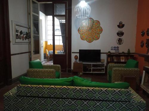 a living room with a green couch and a television at Casa Copada in Montevideo
