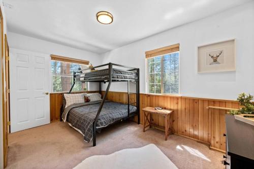 a bedroom with a bunk bed and a table at Cozy Cabin perfect for 2 Families in Big Bear Lake