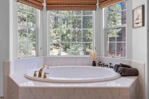 a large tub in a bathroom with windows at Cozy Cabin perfect for 2 Families in Big Bear Lake