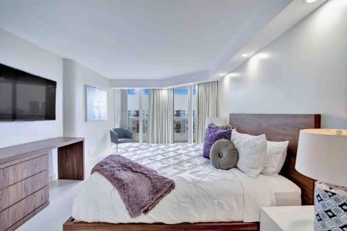 1 dormitorio blanco con 1 cama grande y TV en Summer Retreat! Water and City Views!, en Miami