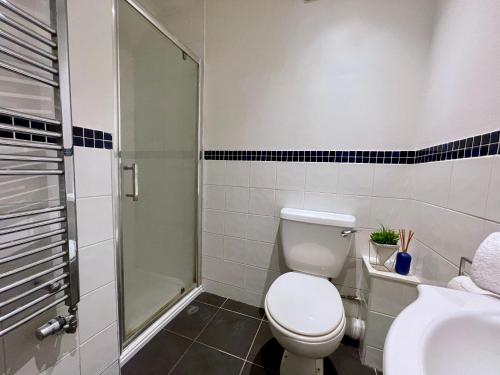 uma casa de banho com um WC e um chuveiro em Sutton - Ground Floor Flat By The High Street em Sutton