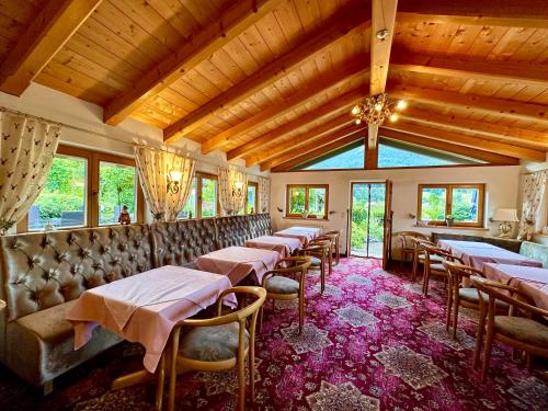 - un restaurant avec des tables et des chaises dans une salle dans l'établissement Hotel Bergland, à Grainau