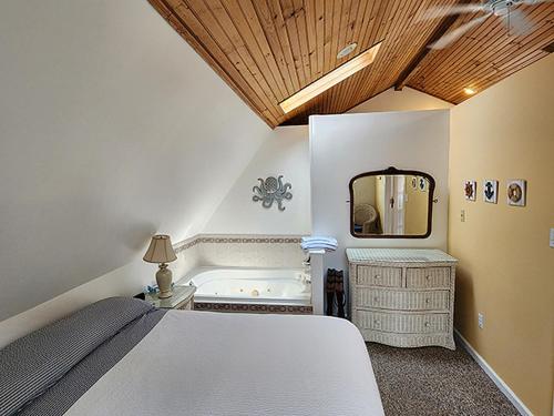 - une chambre avec un lit, un miroir et une baignoire dans l'établissement 2310 Central Avenue, à North Wildwood
