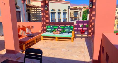a patio with two chairs and a couch on a balcony at Flat One room apartment in talabay aqaba in Al Burj