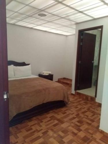 een slaapkamer met een bed en een grote spiegel bij HOTEL DIAMOND in Gachancipá