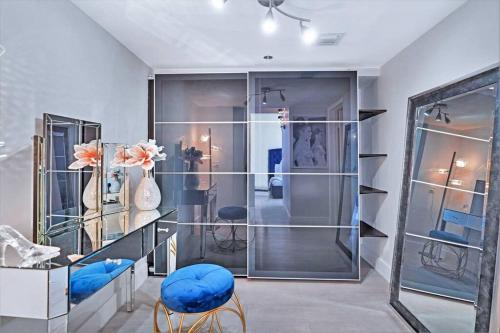 Habitación con estanterías de cristal y taburetes azules en Bay Watch Penthouse! Direct Water Views!, en Miami