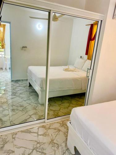 a reflection of a bedroom with a bed and a mirror at Apartamentos felix Las terrenas in Las Terrenas