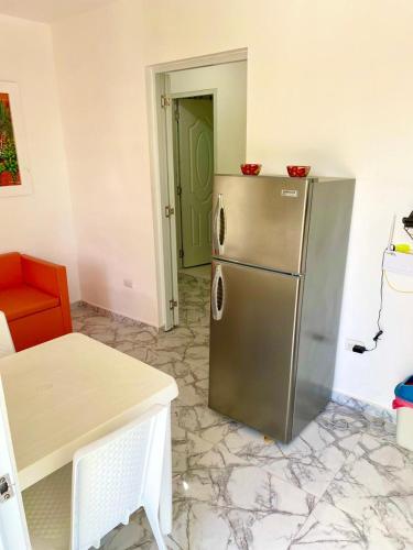 a kitchen with a stainless steel refrigerator next to a door at Apartamentos felix Las terrenas in Las Terrenas
